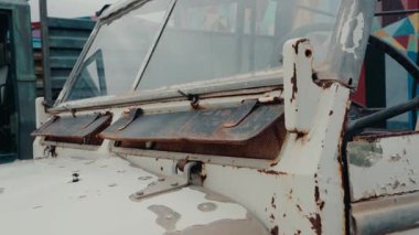 Paslı eski bir Land Rover Defender 'ın yakın plan çekimi. Yıpranmış boyası ve aşınmış metali macera dolu bir hayata işaret ediyor. Nostalji, kabalık hissi uyandırıyor.,