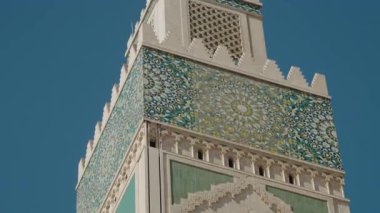Kazablanka, Fas 'taki Hasan II Cami minaresinin yakın çekimleri, güneşli bir günde karmaşık döşemeler ve dekoratif mimari sergileniyor. Bu görkemli yer, Fas sanatına bir göz atma fırsatı sunuyor.