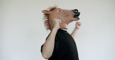 At maskesi takan bir adam beyaz arka planda dans eder. Yumruklarını sallıyor ve enerjik bir şekilde hareket ediyor, eğlenceli ve eğlenceli enerjiyi somutlaştırıyor. Mizah ve kutlama gerektiren projeler için mükemmel.,