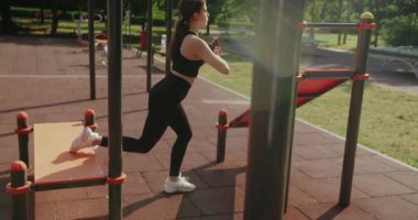 Sportif kadın dışarıda egzersiz yapıyor. Çömelme egzersizi yapıyor. Kadın egzersizi ve antrenman esnekliği dışarıda. Açık hava sporu, antrenman, spor, spor, esneme konsepti. Spor kıyafetleri giyerek..