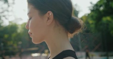 Parktaki fiziksel egzersizden sonra su içen kendinden emin bir kadın, eğitimden memnun, güç ve enerji dolu. Spor giyim sektöründeki kadınlar modern bir parkta çalıştıktan sonra su içiyorlar..