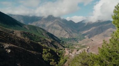 Görkemli dağlarla ve yemyeşil yeşilliklerle çevrili bir vadiye kurulmuş pitoresk bir Fas köyü. Huzur dolu sahne huzur ve sükunet hissi uyandırıyor..