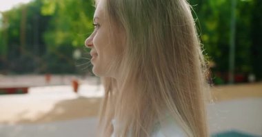 Spor kıyafetleriyle parkta yürüyen çekici bir kadının portresi, yaz gününün keyfini çıkar, kameraya bak ve dışarıda çalışmaya hazırlan, güzel kadın sıcak ve güneş ışığından hoşlanıyor..