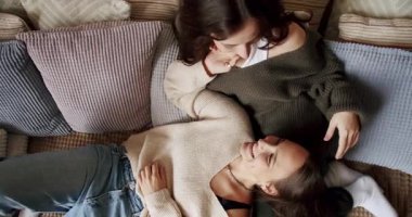Kadınlar ve lezbiyenler evde dinleniyor. Sarılın ve birbirinize sarılın. Sevgiler ve öpücükler Romantik lezbiyen çift eğleniyor. LGBT hakları, lezbiyen ailesi. Sevgi ve desteği paylaşan iki kadın el ele tutuşuyor.