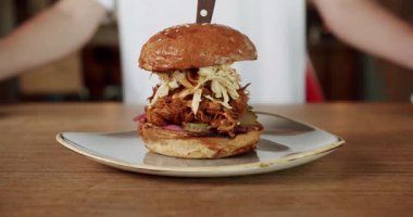 Tabakta servis edilen lezzetli hamburgerler. Fast food restoranında öğle yemeği sırasında tabakta servis edilen bıçaklı lezzetli hamburgerler.