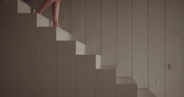 Kübik mobilyalar üzerinde ustalıkla dengede duran bir insanı minimalist bir ortamda yakalayan yaratıcı bir görüntü. Modüler Modüler Mobilya Odasında Zıplayan Kişinin Sanatsal Çekimi