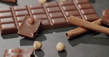 Fındıklı, tarçınlı ve çikolata parçalı sütlü çikolataya yakın çekim, hoşgörü ve tatlılık hissi uyandırıyor. Lezzetli Sütlü Çikolata