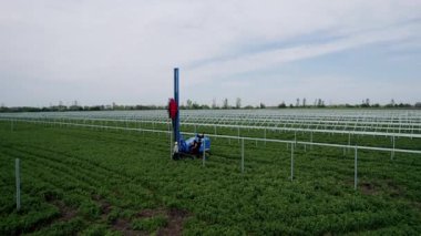 Ekipman ve işçilerle yeşil bir alana güneş panelleri kurma süreci, yenilenebilir enerji ve sürdürülebilirliği destekliyor. Ekipman ve İşçilerle Yeşil Alan 'a Güneş Panelleri Kurulumu