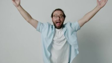 Heyecanlı adam sevinçle atlıyor, kusursuz beyaz stüdyo geçmişiyle başarıyı kutluyor. O pozitif enerji, mutluluk ve başarı doludur..