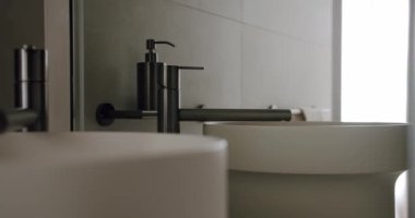 Çağdaş banyo iç tasarımı, gösterişli musluk ve lavabo ile minimalist bir tasarım sergiliyor. Huzurlu bir ortamda modern estetik ve zarif eşyalar. Modern Minimalist Banyo İçi
