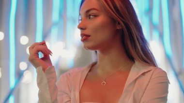 Şık bir kadın portresi neon ışıklarla aydınlatılmış kentsel bir gecede eğleniyor. Kendine güveni ve zarafeti var. Şehir Gece Yaşamında Şık Kadın, Neon Işıkları Arkaplanıyla Ayarlama