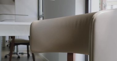 Şık bir Çalışma Alanındaki Zarif Ofis Başkanı ve Modern Masa. Bej renkli deri bir ofis sandalyesi ve beyaz modern bir masa. Parlak, çağdaş bir ofis alanı..