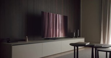 Zarif, koyu renk ahşap paneller, düz ekran televizyon ve lüks ve çağdaş bir yaşam tarzını vurgulayan gösterişli mobilyaların yer aldığı modern bir minimalist oturma odası. Modern Minimalist Oturma Odası