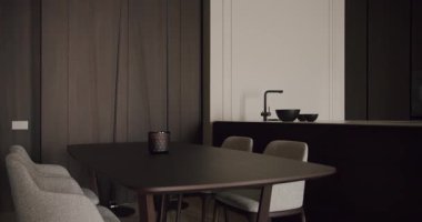 Karanlık ahşap mobilyalar, modern dekorlar ve temiz çizgilerden oluşan gösterişli ve minimalist bir mutfak ve yemek alanı. Dekor çağdaş ve sofistike bir ortam yayıyor. Minimalist Mutfak