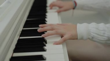 Müzik dersi veren genç bir müzisyen. Sessiz bir kişi dairesinde otururken piyano çalışır. Eller piyano tuşlarına basıyor. Nota okuyorum. Piyano öğrenme dersleri