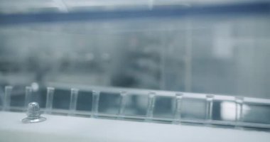 İlaç Atılgan 'daki laboratuarda cam şeffaf şişelerle birlikte taşıyıcı. Enjeksiyon paketleme hattına transfer edin. İlaç üretim hattı, üretim sırası, kemer ya da taşıyıcı.