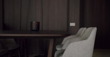 Gri döşemeli minimalist dekorasyonlar ve koyu ahşap bir masa ile modern yemek odası sofistike ve zarif bir havayı çağrıştırıyor. Minimalist Dekorlu Modern Yemek Odası