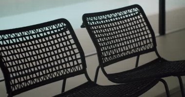 Bir çift siyah hasır sandalye bulanık arka planda kurulmuş, minimalist ve modern bir estetik yaratıyor. Minimalist Tarz Odasında İki Kara Hasır Sandalye