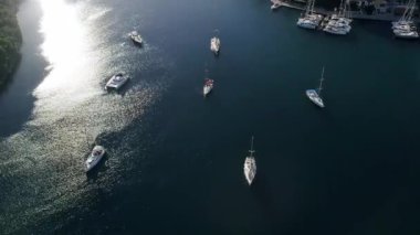 Lüks yelkenli. Yaz lüks modern tekne gezisi. Lefkada adası. Yat için liman. Marinadaki tekne ve yatların yukarıdan görünüşü. Koyu mavi sularda beyaz teknenin görüntüsü.