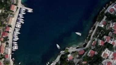 Marinadaki tekne ve yatların yukarıdan görünüşü. Yat parkı, Yeşil Dağlar adasında yaz deniz gezisi. Beyaz yat. Koyu mavi sularda beyaz teknenin görüntüsü.