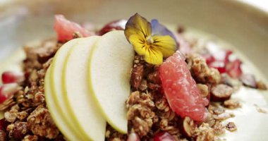 Tahıl gevreğiyle sağlıklı bir kahvaltı. Lezzetli Müsli gevreği. Kapatın. Bir kase dolusu gevrek gevrek gevreği greyfurt, nar, fındık, sarı amber ve yoğurt..