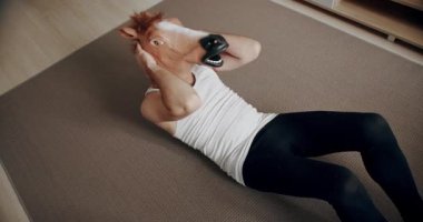At maskeli komik adam evde miyofasyal rahatlama egzersizi yapıyor. Evde komik bir spor salonu var. Sağlık ve Spor Konsepti. Öğle yemeği arasında sırt ağrısı. Karın için egzersizler..