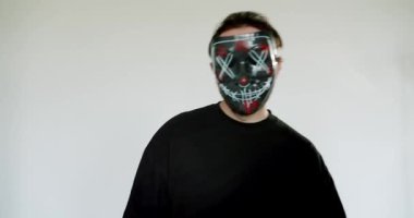 Arınma maskeli bir adam parayı sayar ve havaya fırlatır. Adam siyah bir gömlek giyiyor ve beyaz bir arka plana karşı duruyor. Para, maske, sayma, fırlatma, tasfiye, adam, erkek, siyah gömlek,