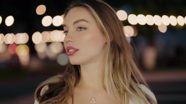 Uzun saçlı, kolye takan genç bir kadının yakın plan portresi gece bulanık şehir ışıklarının altında. Arka planda Şehir Işıklarıyla Gecedeki Genç Kadın Portresi. Genç Kadın.