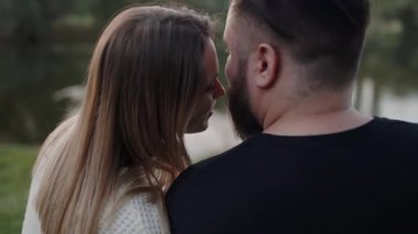 Şefkatle kucaklaşan, alınlarına dokunan, yakınlık ve bağ hissi uyandıran bir çiftin yakın plan çekimi. Dusk 'ta sevgili çiftler arasında hassas bir an.