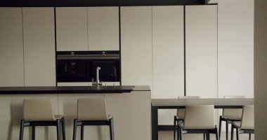 Zarif ve modern bir mutfak. Parlak siyah tezgahlar, dahili aletler ve minimalist beyaz dolaplar. Çağdaş ev tasarımı için mükemmel. Cihazlı Modern Mutfak
