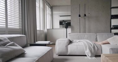 Lüks minimalist tasarım, beyaz ve gri tonlu gerçek daire, zarif sandalye ve lüks mobilyalar, beyaz halı ve siyah ses teknikleri, beton, modern mutfak odası. Modern oturma odası.