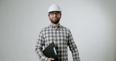 Kendinden emin bir mühendis elinde panoyla kameraya doğru yürüyor. Durdu, kameraya baktı ve gülümsedi. Uzmanlık, profesyonellik ve güvenlik açıktır.