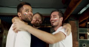 Futbol taraftarları takımın zaferini spor barında kutluyorlar. Sadık futbol taraftarları takımlarını destekliyor. Pub 'daki arkadaşlar. Destekçiler. Mutlu karışık ırk destekçileri kazandıktan sonra seviniyor ve alkışlıyorlar..