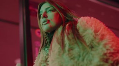 Gece lambalarının arka planında genç bir kadının portresi. Şehir, gece, kız, ışık, dışarıda. Model pozu şehir caddesi. Geceleri şehir merkezinde poz veren güzel bir kadın..