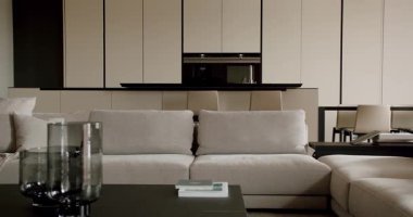 Bu resim, sofistike ve sakin bir ortam sağlayan minimalist tasarımı, nötr renkleri ve temiz çizgileri olan modern bir oturma odasını gösteriyor. Zarif Minimalist Tarzlı Modern Oturma Odası Tasarımı