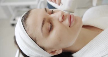 Profesyonel bir kozmetik uzmanı kadın hastalarla güzellik salonunda yüz işlemleri yapar. Yüz derisi mekanik tedavi sürecine yakın çekim. Güzellik kraliçesiyle yüzleş..