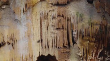 Sarkıtların ve mağaranın içindeki renkli mineral oluşumlarının karmaşık detaylarını gösteren nefes kesici bir fotoğraf. Bu görüntü yeraltı güzelliğini canlı detaylarla gözler önüne seriyor..