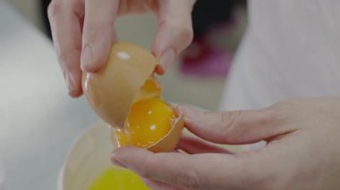 Mutfak ortamında yumurta sarısını yumurta beyazından ustalıkla ayırarak pişirme hazırlıklarını gösteren yakın plan çekimler. Mutfakta Yumurta Yumurtası Sarısını Ayrıştıran Ellerin Yakın Çekimi