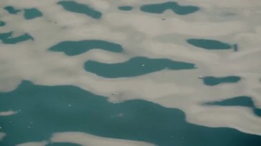 Dalgalanmalı ve beyaz köpüklü turkuaz suya yakın çekim sakinleştirici ve sakin bir atmosfer yaratır. Bu stok görüntülerini doğa, rahatlama, seyahat ve meditasyonla ilgili projeler için kullanın.