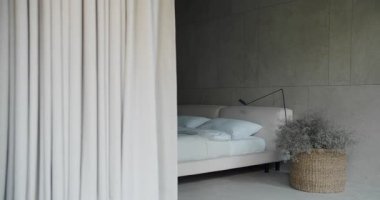 Minimalist bir yatak odası, yumuşak gri duvarlar ve doğal dekorasyonlarla sakinleştirici bir atmosfer yaratıyor. Tarafsız Tonlar ve Zarif Dekorlu Modern Yatak Odası Tasarımı