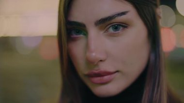 Çekici bir kadın portresi. Model pozu şehir caddesi. Geceleri şehir merkezinde poz veren güzel bir kadın. Sokaktaki doğal güzellik kraliçesi. Yavaş çekim.