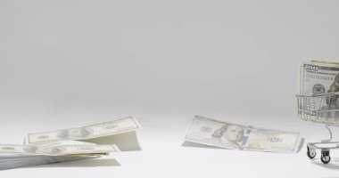 Adamın biri bir Amerikalıyı 100 dolarlık banknotla arka plandaki para arabasına itiyor. 100 dolarlık banknotlar. Konsept Finans İş Yatırımı Başarı. ABD 'nin zengin iş ekonomisi.