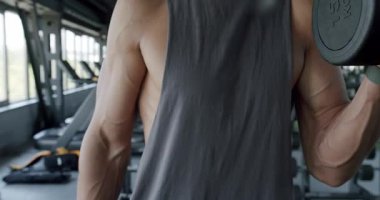 Kaslı Adam Modern Spor Salonu 'ndaki antrenmanına odaklandı. Spor salonunda çalışan kaslı bir adamın yakından görüntüsü kendini adamışlığını ve formunu gösteriyor..