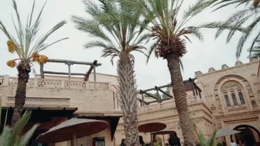 Palmiyeler rüzgarda hafifçe sallanarak Fas avlusunun dingin atmosferini artırıyor. Geleneksel mimari ve tasarım elementleri zamansız güzellik hissi yaratır..