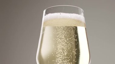 Glass of champagne on white isolated background. Champagne bubbles. Slow motion and super macro shot of tiny air bubbles flowing upwards in elegant glass of champagne on a white background