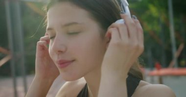 Spor salonunda beyaz kulaklıklı, güzel, beyaz saçlı esmer bir kadının portresi. Boş zaman. Mutlu, spor ve müzik dinleyen kişinin portresi.