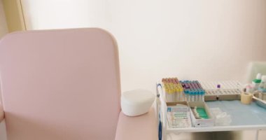 Sandalyesi, masası ve çeşitli tıbbi gereçleri olan parlak ve temiz bir klinik. Ekipman ve Malzemelerle Modern Tıbbi Klinik İçi