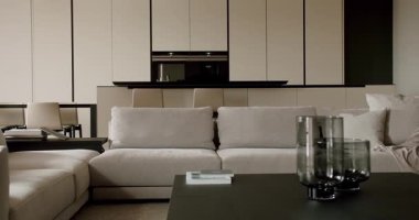 Zevkli dekore edilmiş modern bir oturma odasında rahat bir kanepe, şık bir kahve masası ve minimalist bir dolap bulunur. Nötr renk şeması uzayın çağdaş estetiğini geliştirir