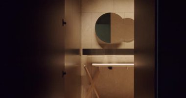 Tarafsız renklerde, sıcak ve ince ışıklandırmalı minimalist bir tasarımın yer aldığı çağdaş bir banyo manzarası. Bu resim modern iç tasarımın zarafetini ve basitliğini yakalar..