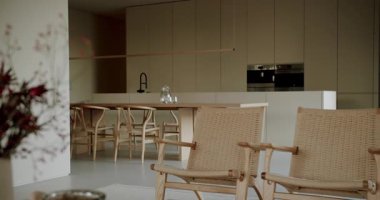 Modern, minimalist mutfak, ahşap mobilyalar ve tarafsız renkler. Açık-plan tasarımı bir ferahlık ve sakinlik hissi yaratır. Doğal ışık, iç mekanı aydınlatır. Basit bir yaşam tarzı..